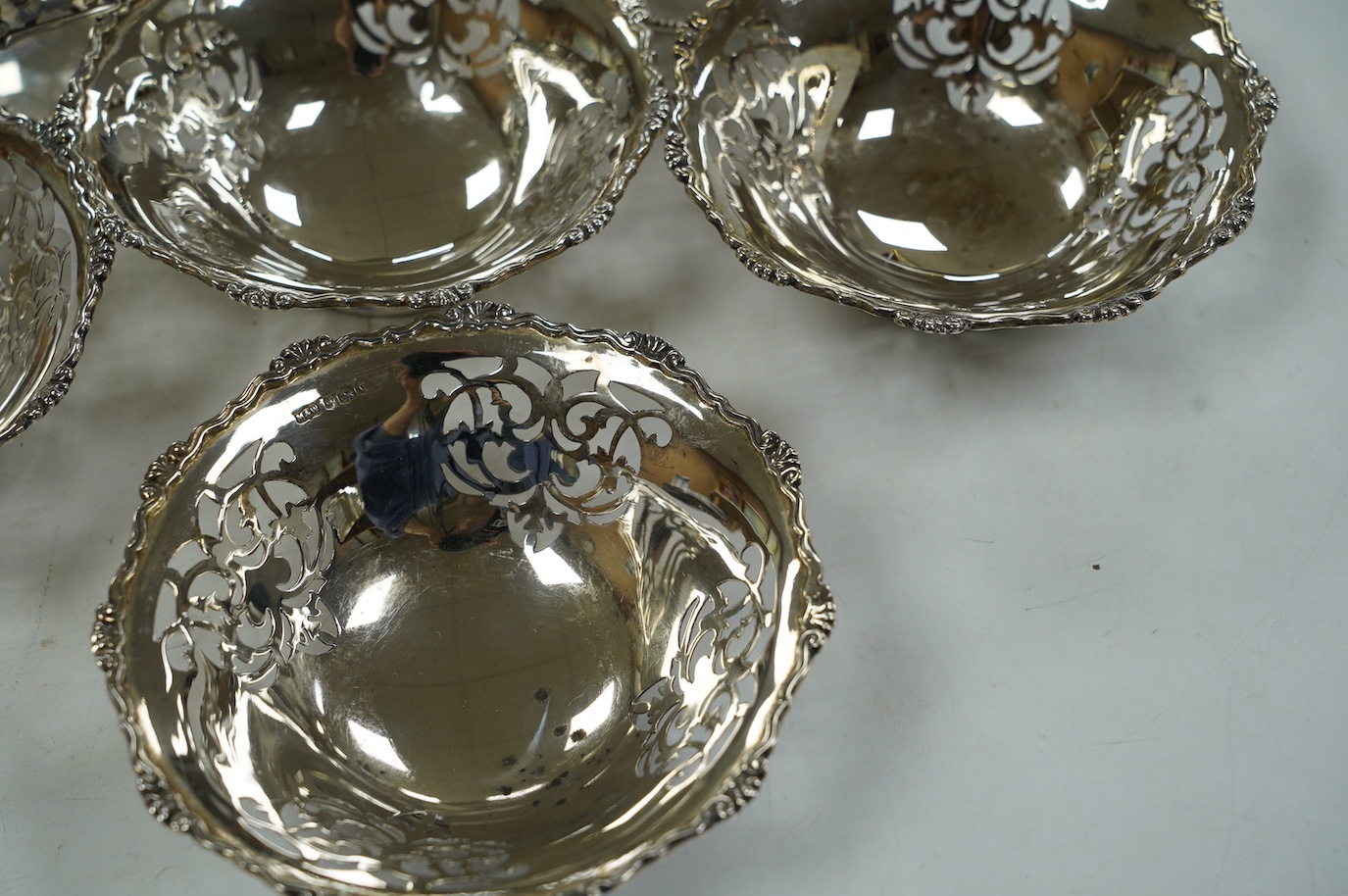 A set of four George VI pierced silver bonbon dishes, by Mappin & Webb, Sheffield, 1938, diameter 12cm and an earlier pair of silver bonbon baskets, 15.7oz. Condition - fair